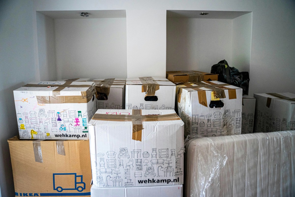 a bunch of cardboard boxes are stacked on top of each other in a room .