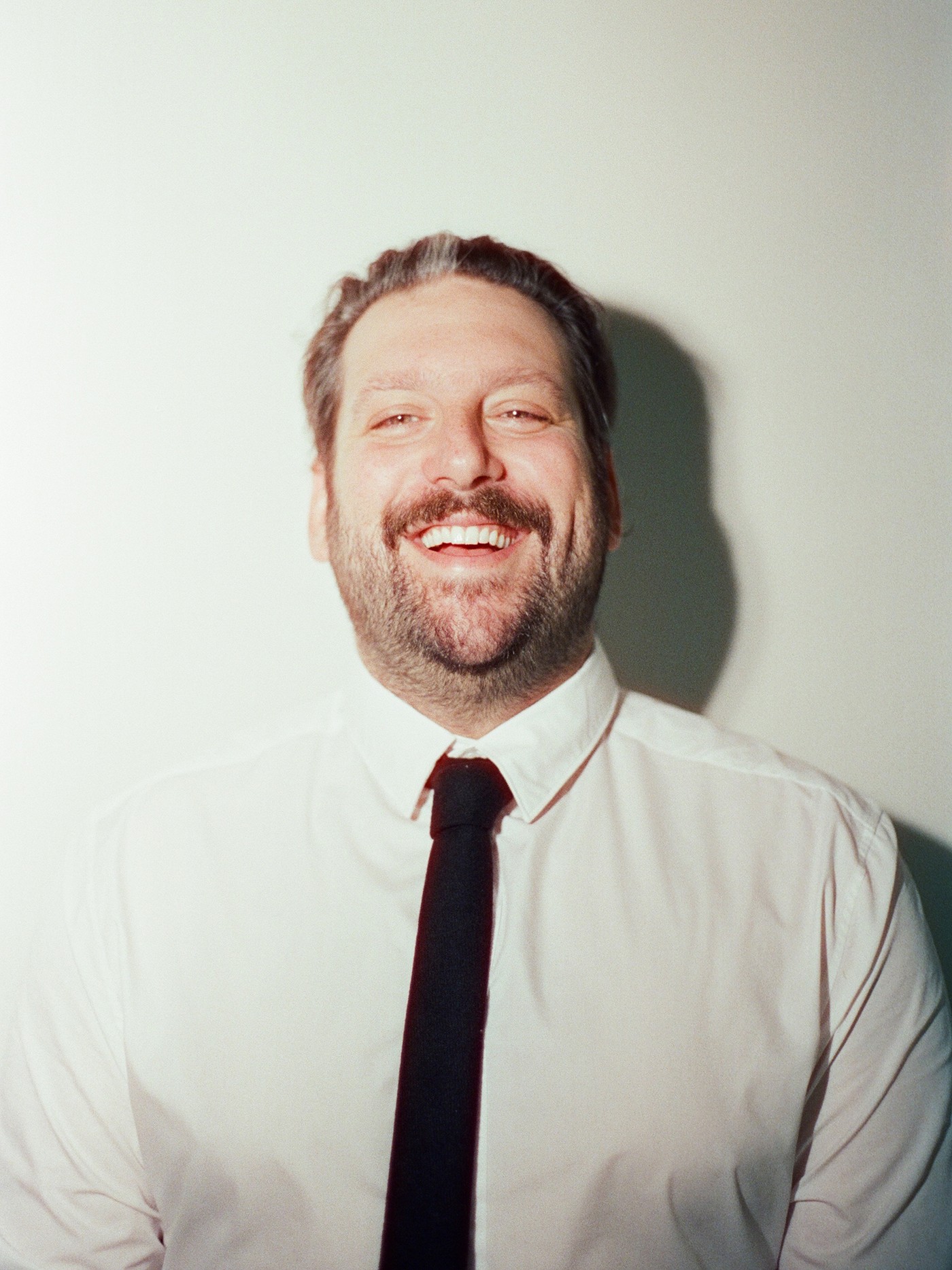 Max Marschark, a man with a beard wearing a white shirt and black tie