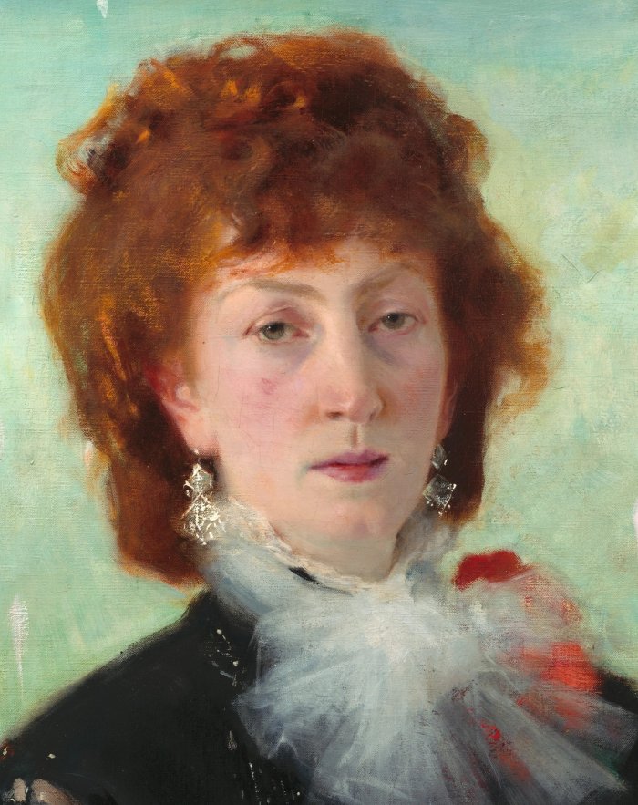 A detail from John Singer Sargent’s portrait of Marie Buloz Pailleron: a red-haired woman in a black dress with a white lace jabot, against a pale green background.