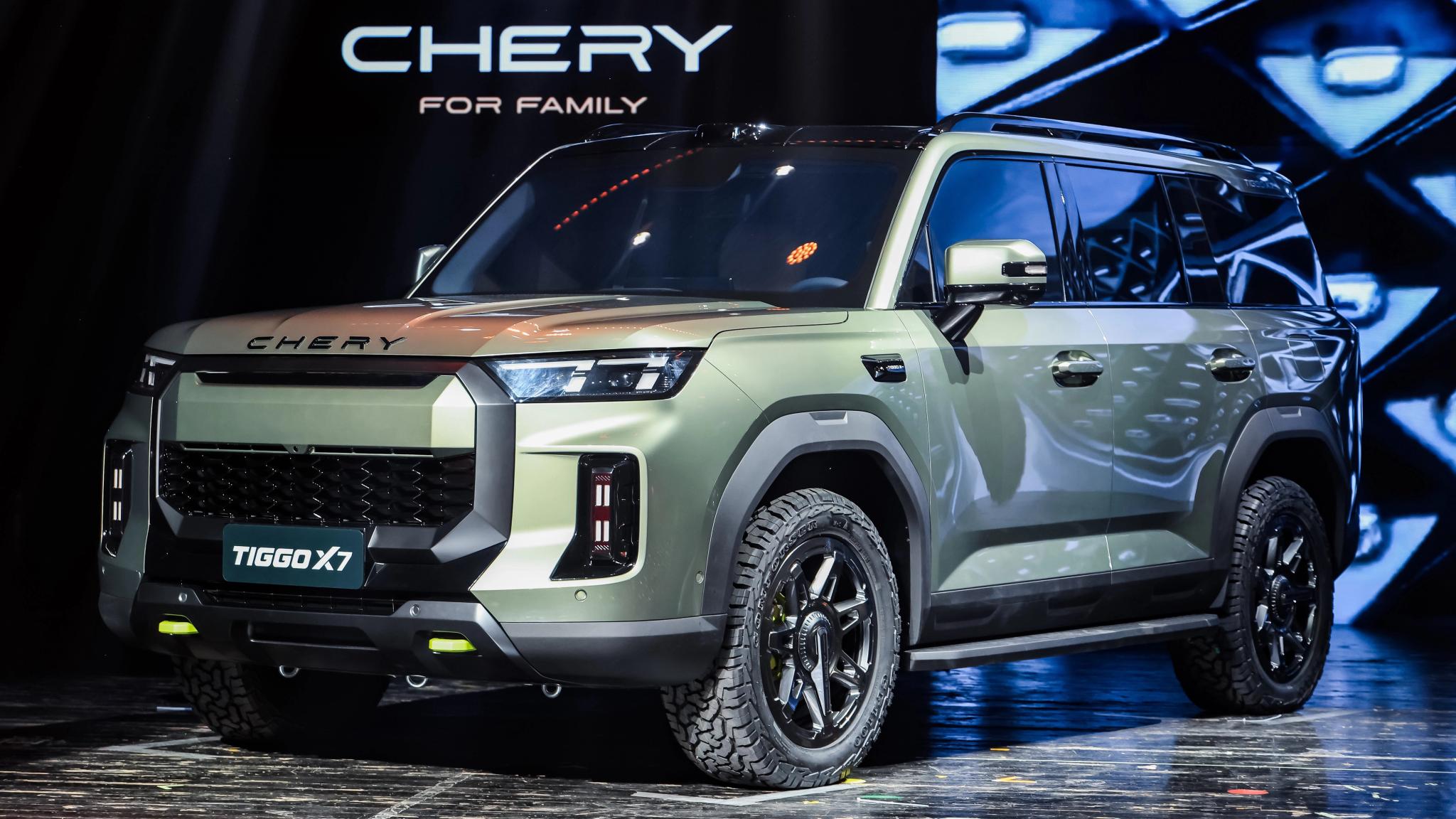 Green Chery Tiggo X7 SUV in front three-quarter view, showing boxy styling and all-terrain tyres