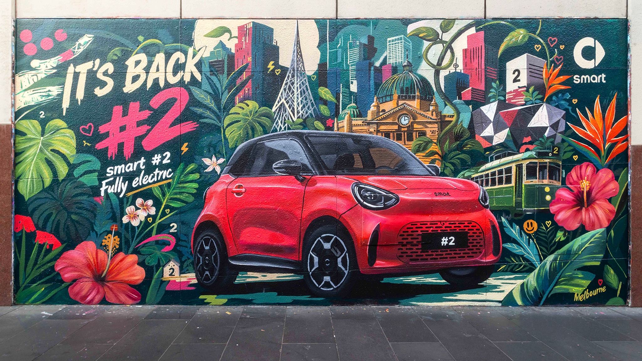 2027 smart #2 electric city car shown in red on a Melbourne street mural by artist Georgia Laurie ahead of its Paris debut