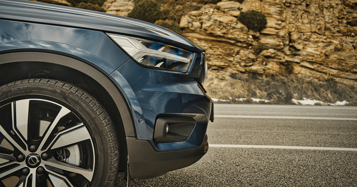 Close up of an SUV front wheel and headlight on a roadside