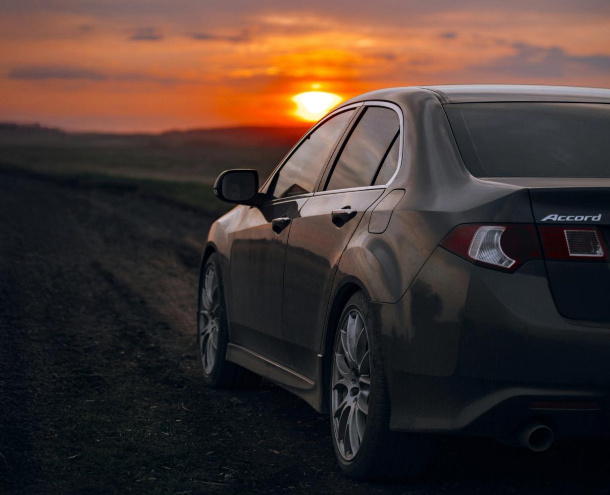 Honda Accord parked in front of a sunset landscape.