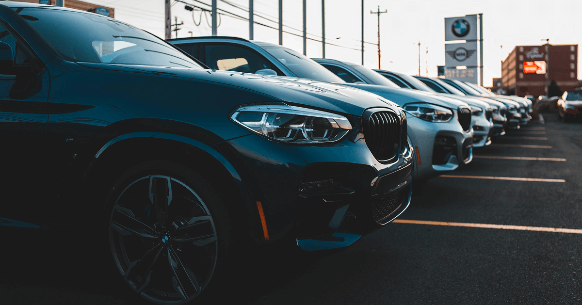 Row of new cars parked at a dealership lot