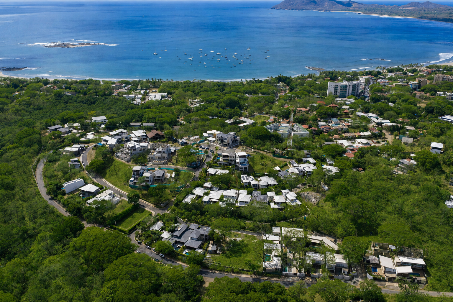 Aerial view of Tamarindo Park homes with standing-seam roofs, solar panels and private pools