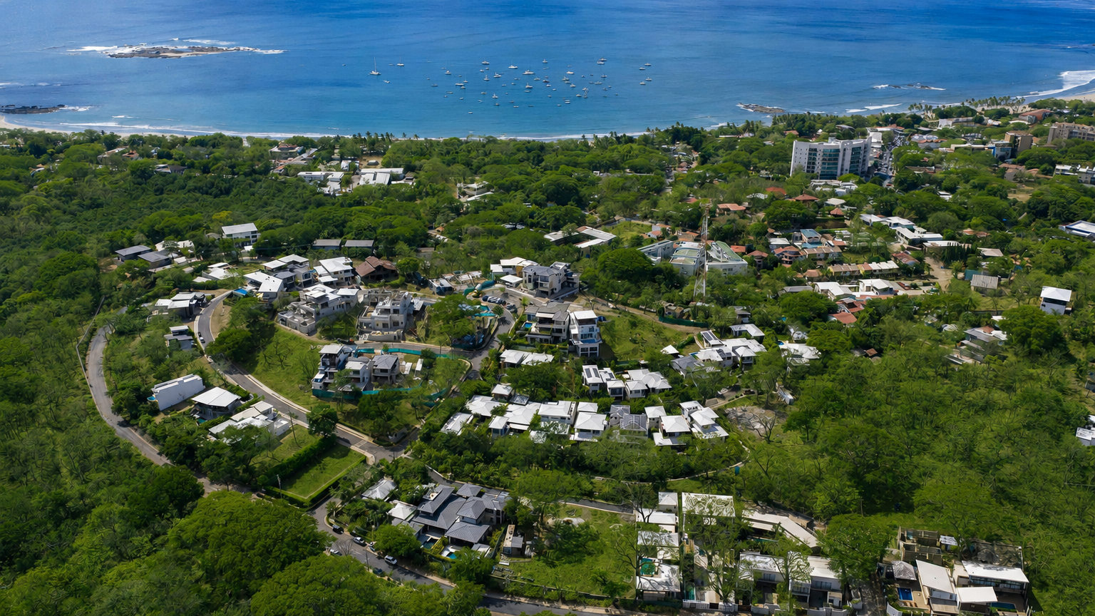 Aerial view of Tamarindo Park homes with standing-seam roofs, solar panels and private pools