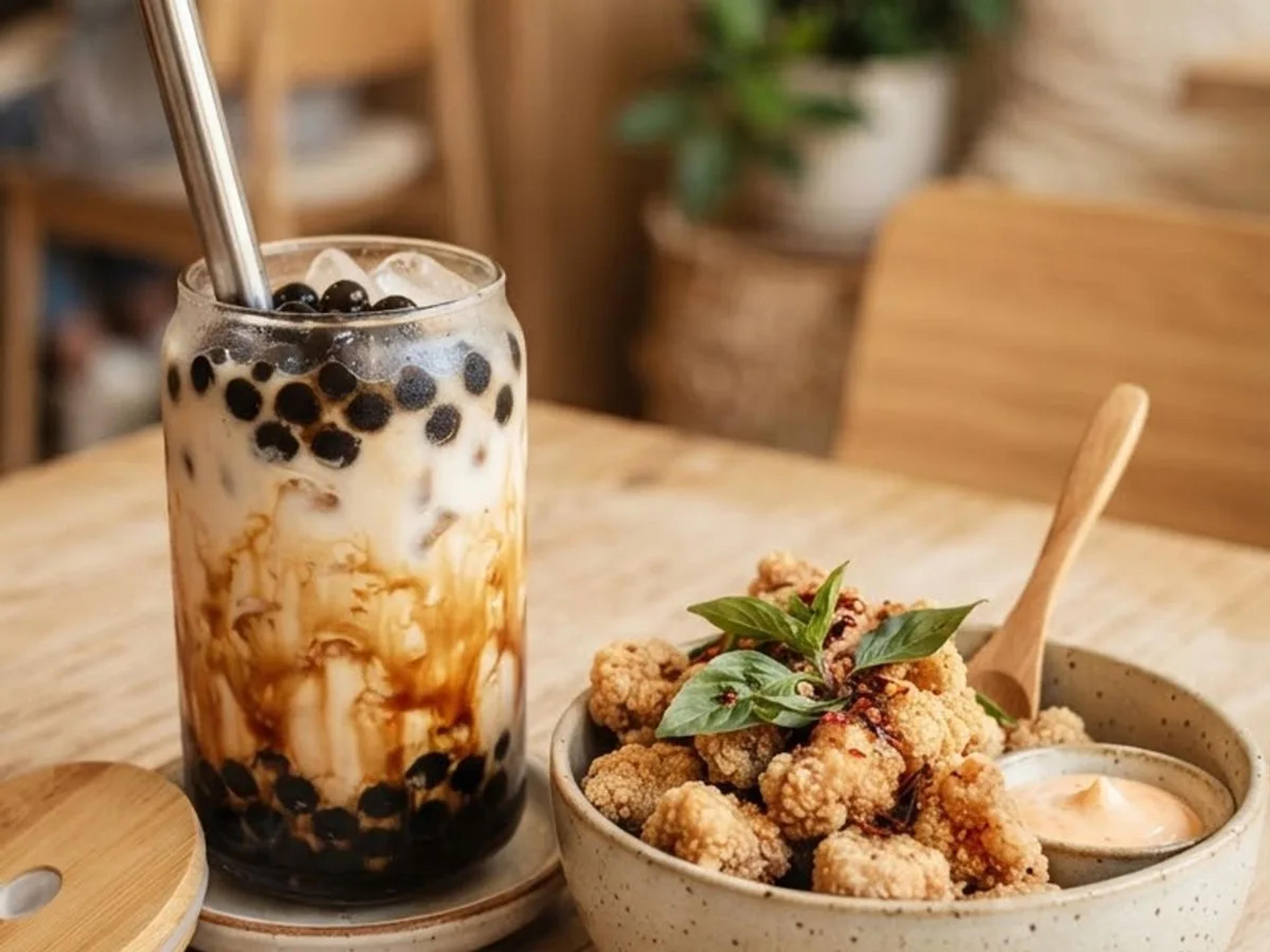 A brown sugar boba alongside a bowl of Taiwanese popcorn chicken