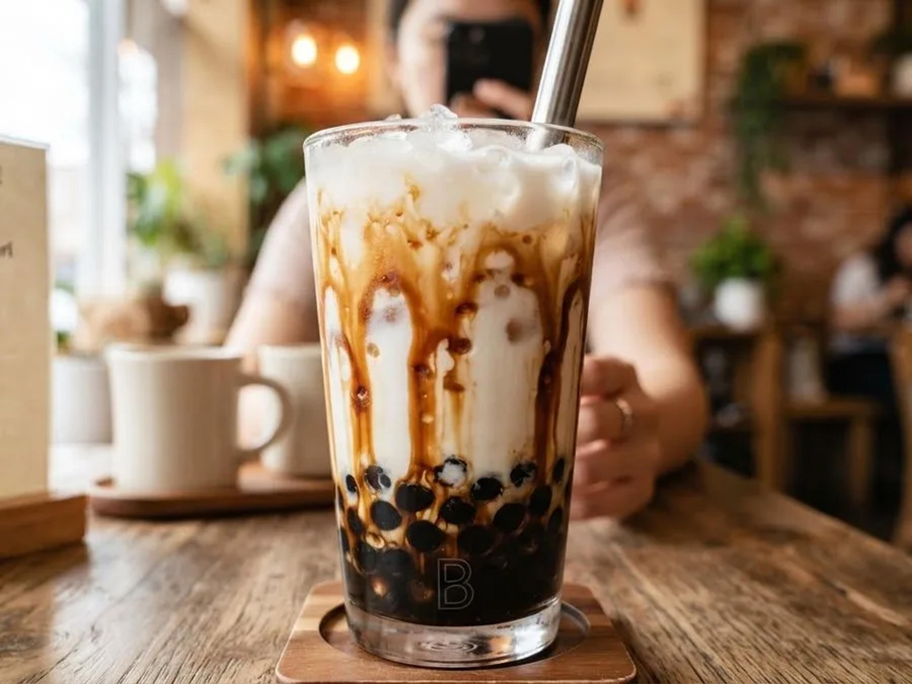 Brown Sugar Milk with dark syrup streaked down the glass over tapioca pearls
