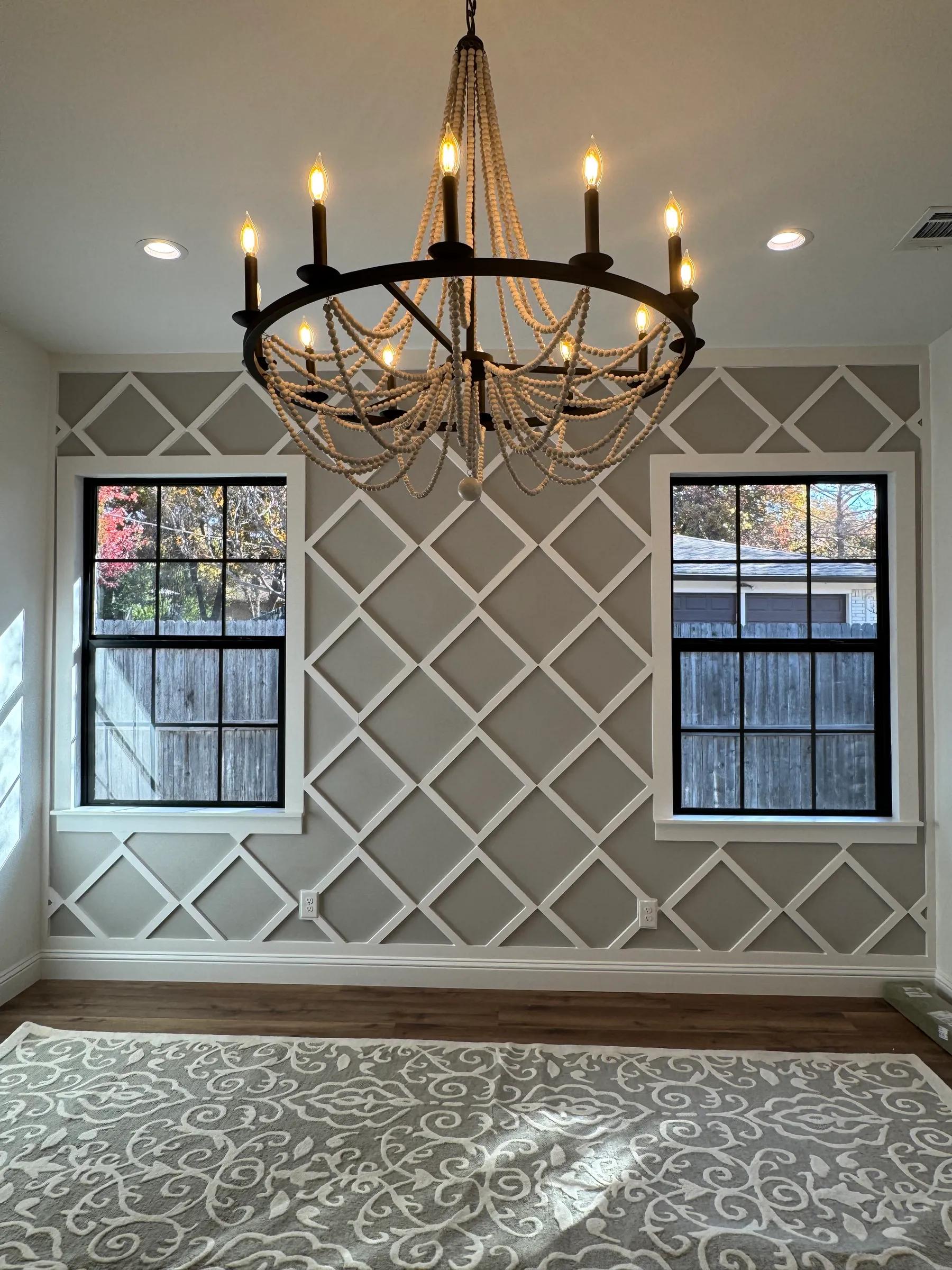 Dining room with a wood bead chandelier, gray trellis wall paneling, and black-framed windows