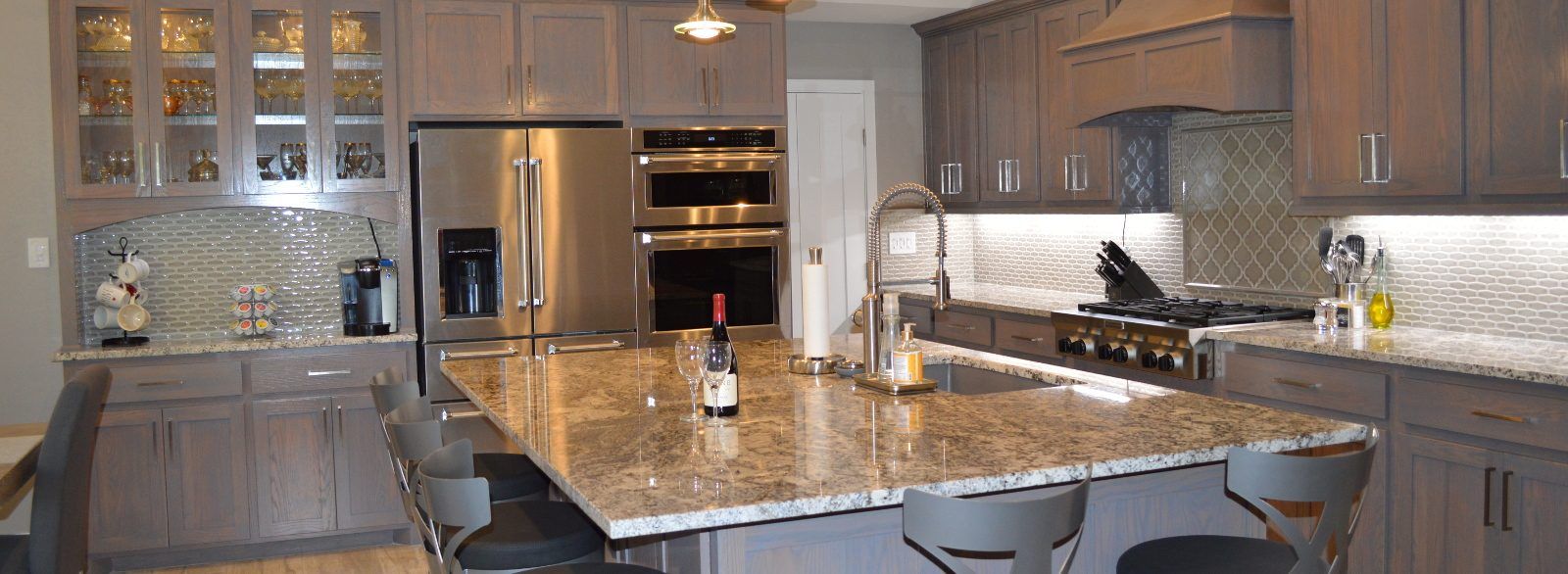 Remodeled kitchen with a granite island, stainless appliances, and gray cabinets
