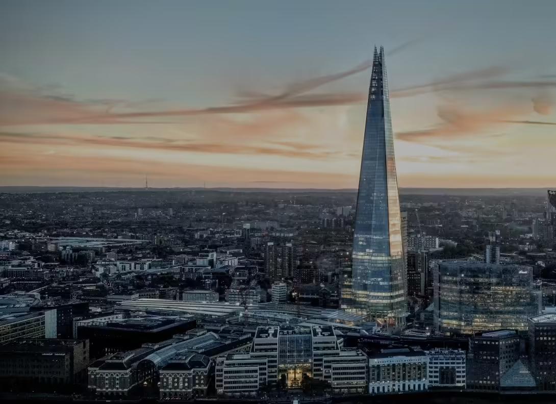 The Shard rising above the London skyline at dusk, with the lit city spread out below