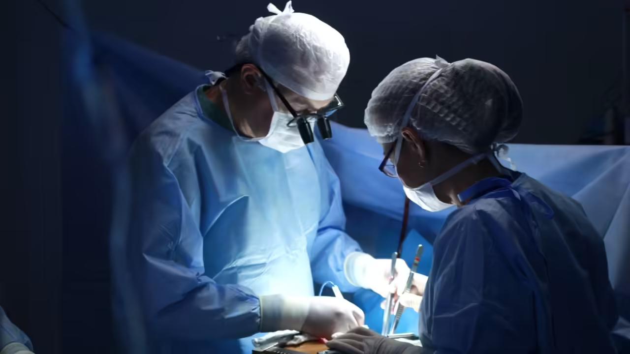 Two surgeons operating at the table in theatre