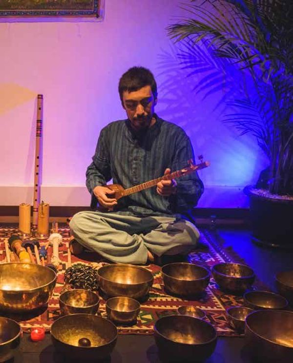 Gustavo Adolfo Pérez Jiménez tocando un setar entre cuencos tibetanos