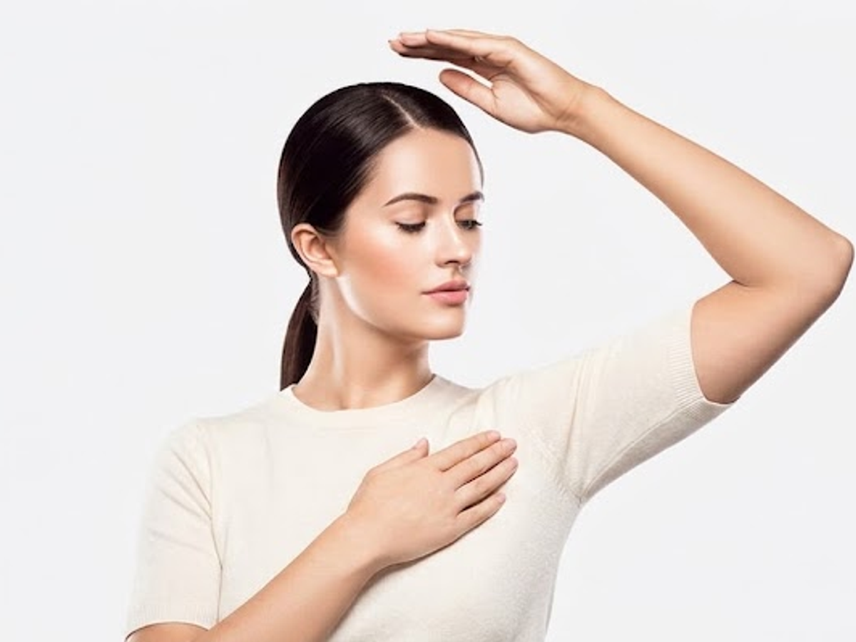 Woman raising her arm to display smooth underarm skin for non-surgical arm lift results in Ajax