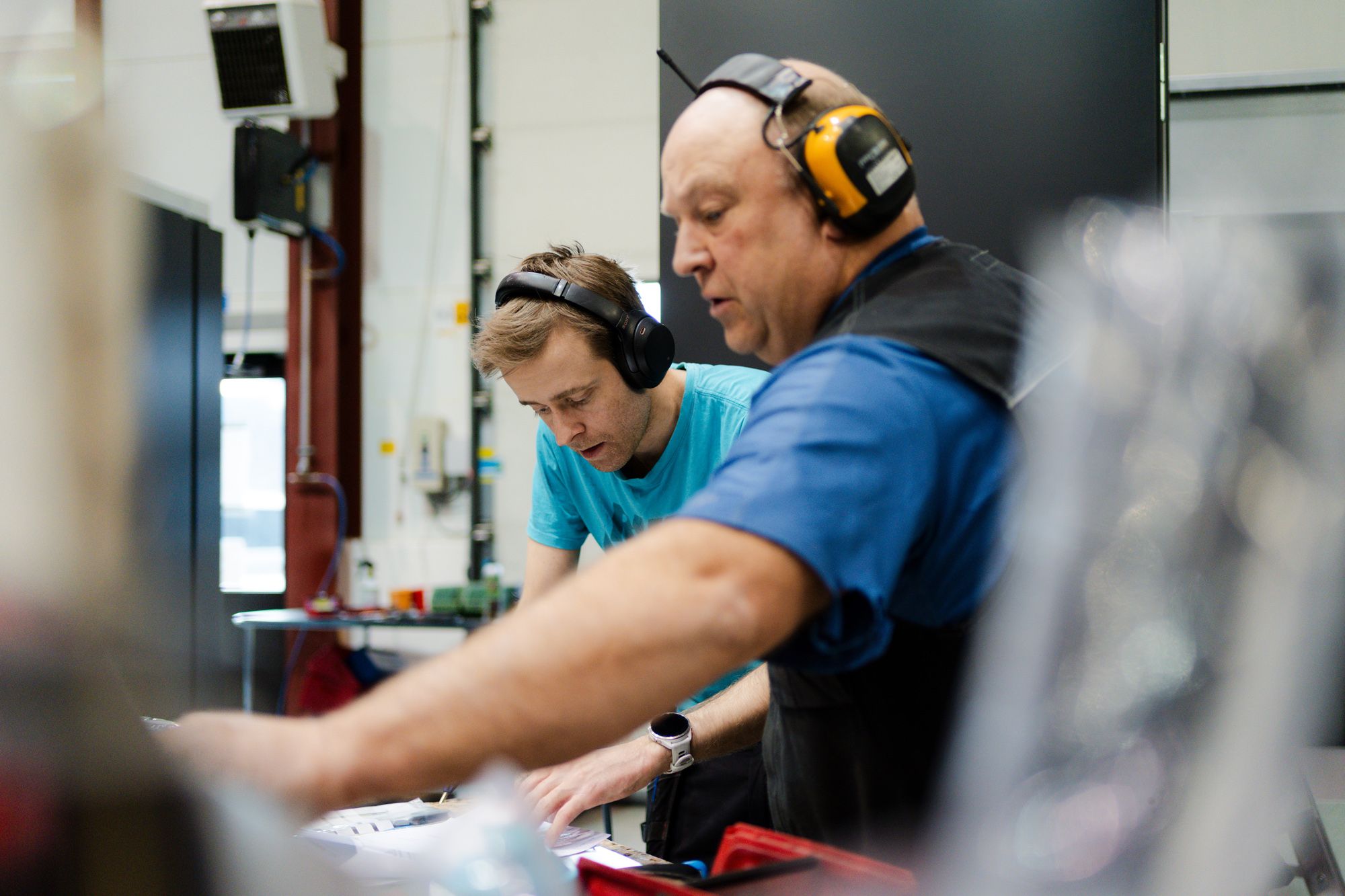 Fagarbeider med verneutstyr ved produksjonslinje