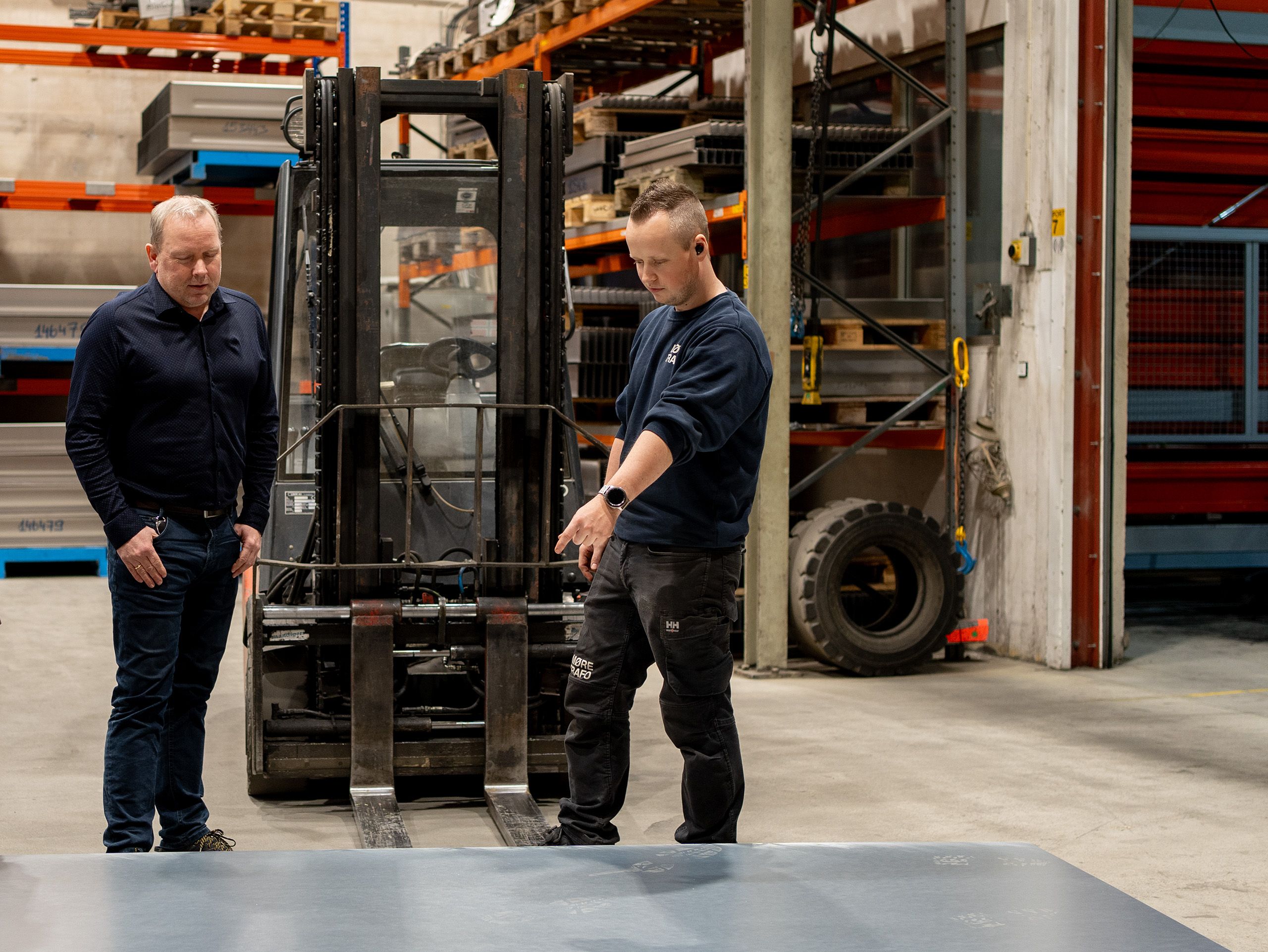 Lærling og fagarbeider i samtale ved produksjonsutstyr