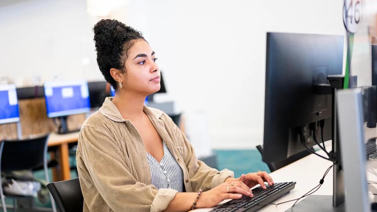 A woman learning at a computer in a computer lab. Image: Google.