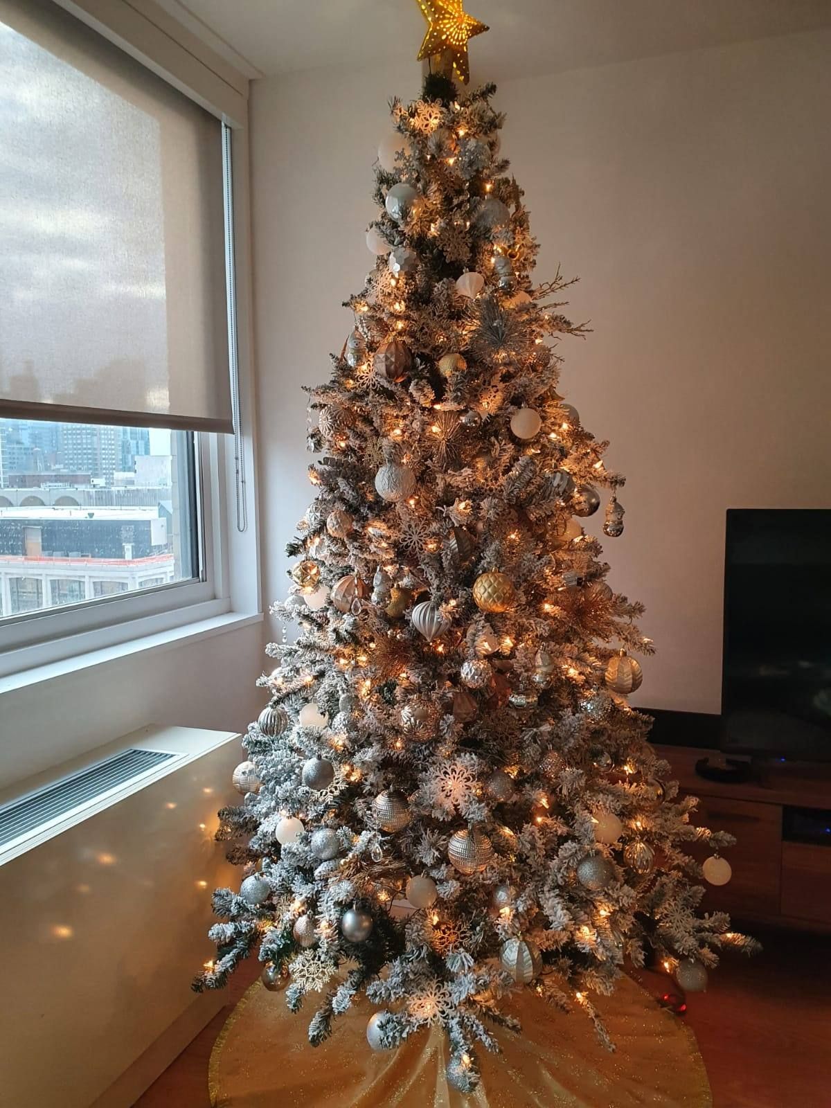 A decorated flocked Christmas tree in living room