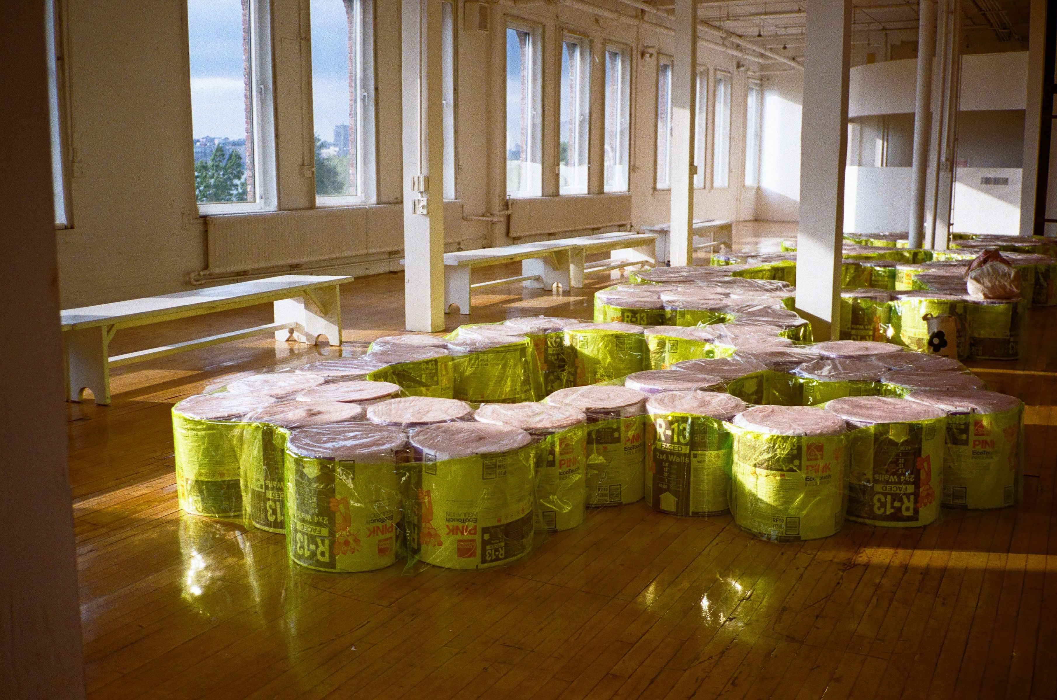 Rolls of insulation with fluorescent vinyl covering for a runway show designed by Almost Studio
