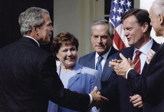 After signing the AUSFTA in Washington on  3 August 2004, President George W Bush shakes hands with Michael Thawley, as Agriculture Secretary Ann Veneman, Commerce Secretary Don Evans and Senator Orrin Hatch look on
