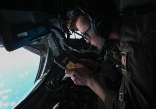 A US Air Force air-to-air boom operator prepares to refuel a Royal Australian Air Force P-8A Poseidon aircraft during a training mission near the Philippine Sea, October 2021