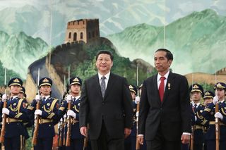 Chinese President Xi Jinping accompanies Indonesia's President Joko Widodo to view an honour guard inside the Great Hall of the People, March 2015
