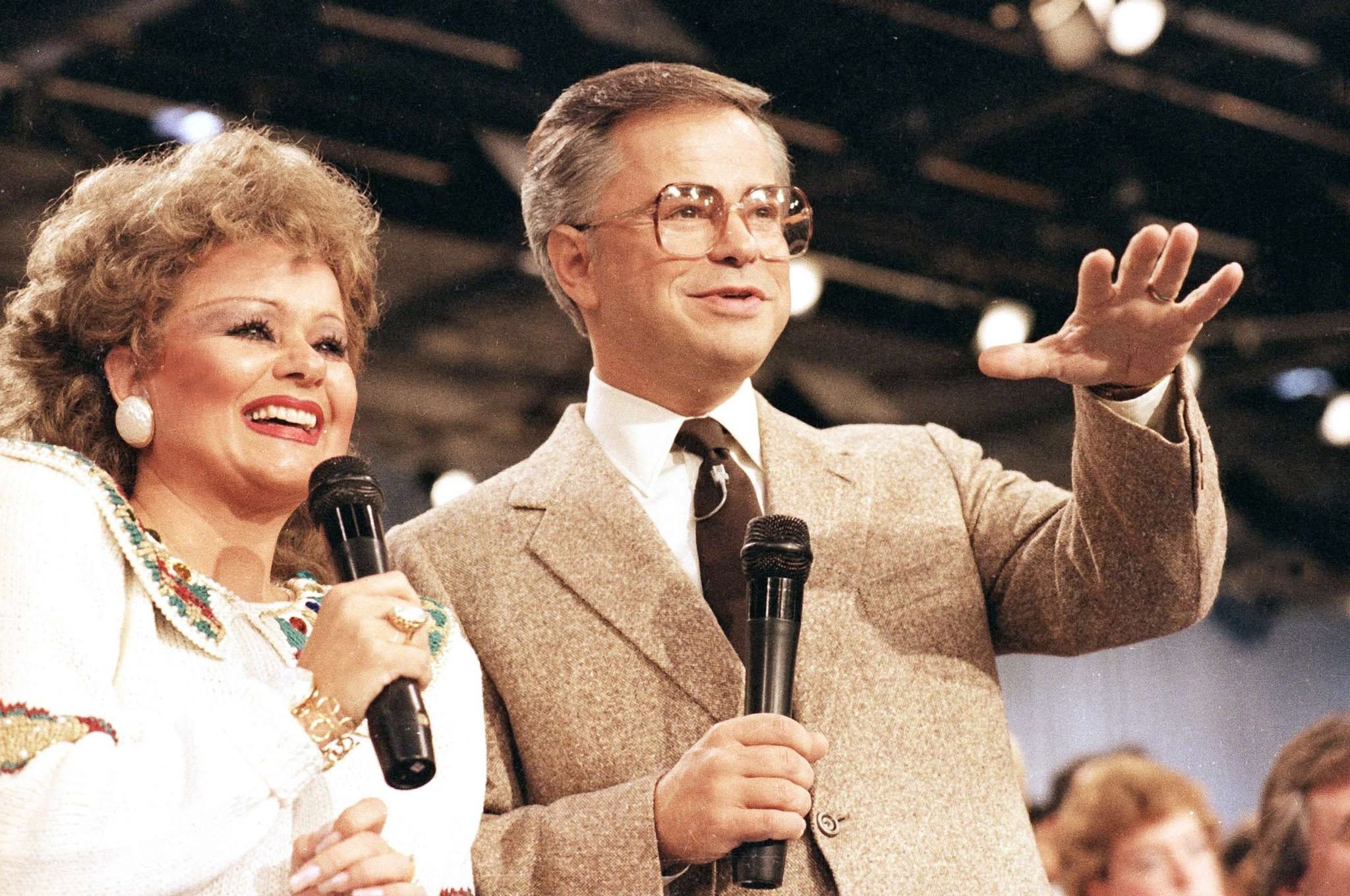 Tammy Faye Bakker and her then-husband, television evangelist Jim Bakker, talk to their TV audience at their PTL ministry near Fort Mill, SC, 20 August 1986