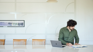 USSC student studying at a table with a laptop and book
