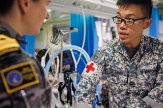 Republic of Singapore Navy officer Captain (Dr) Ruedi Chan from the Navy Medical Service speaks with RAN officer Lieutenant Commander Shannon Godfrey during Exercise Trident 2022, Queensland