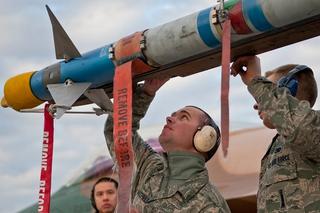 Aircraft armament systems weapons load team members with the 57th Aircraft Maintenance Squadron secure an AIM-9 Sidewinder air-to-air missile on an F-16 Fighting Falcon aircraft at Nellis Air Force Base
