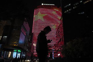 A man looks at his phone near a giant image of the Chinese national flag on the side of a building in Beijing, during the ongoing 19th Communist Party Congress on October 23, 2017
