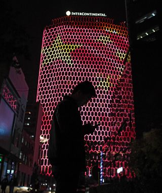 A man looks at his phone near a giant image of the Chinese national flag on the side of a building in Beijing, during the ongoing 19th Communist Party Congress on October 23, 2017