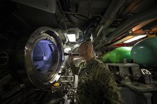 Examining a torpedo tube aboard the Virginia-class fast-attack submarine USS Illinois