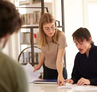 Two people collaborating at a kitchen bench.