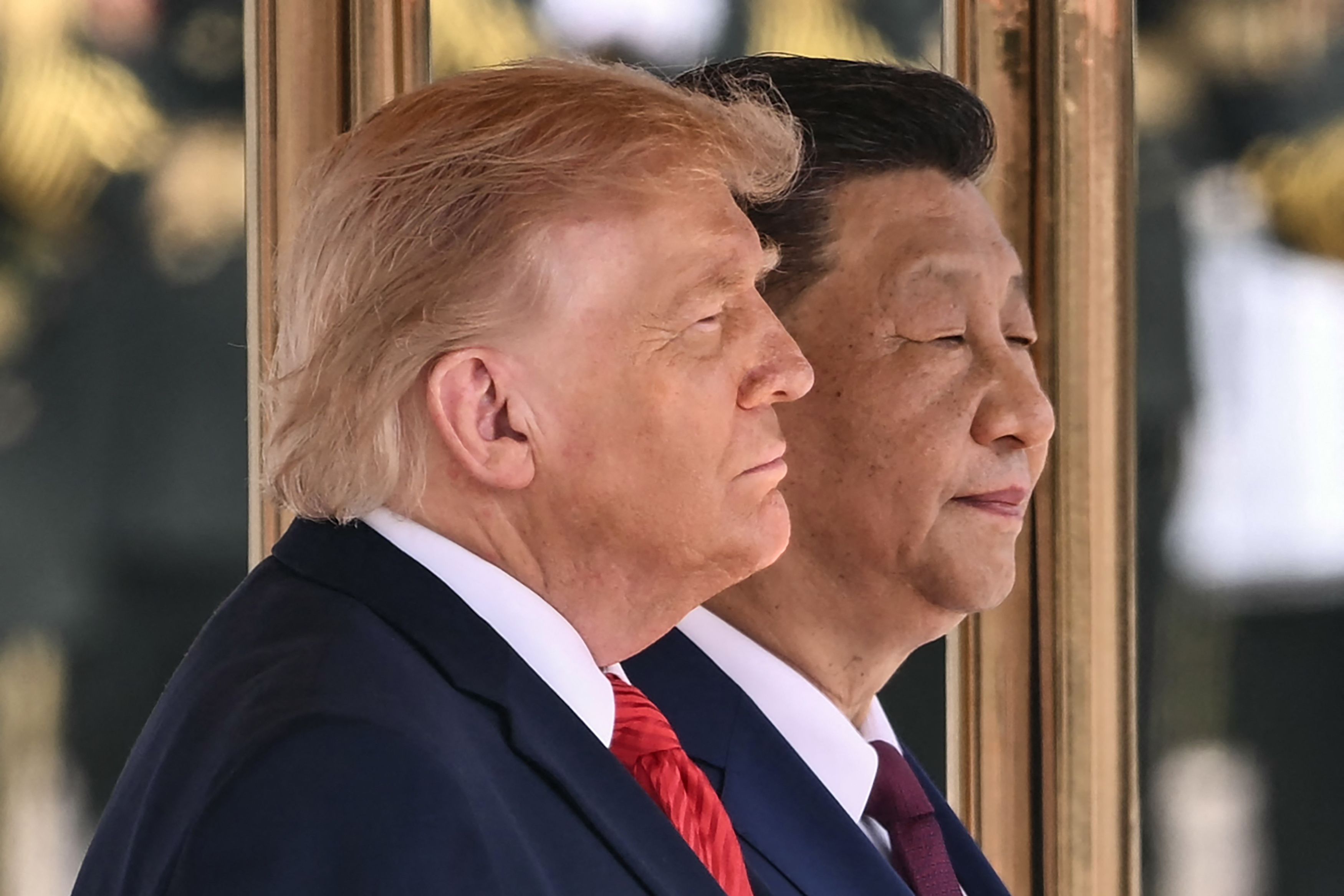 US President Donald Trump (L) and China's President Xi Jinping stand for their countries' national anthems during a welcome ceremony at the Great Hall of the People in Beijing on May 14, 2026. 
