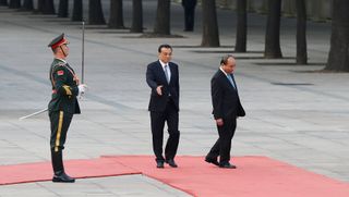Chinese Premier Li Keqiang accompanies Vietnamese Prime Minister Nguyen Xuan Phuc to view an honour guard during a welcoming ceremony in Beijing