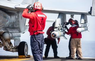 US sailors load munitions onto an F/A-18E Super Hornet, USS Ronald Reagan (June 2019)