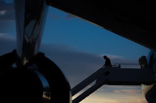 President Donald Trump disembarking from Air Force One at dusk.