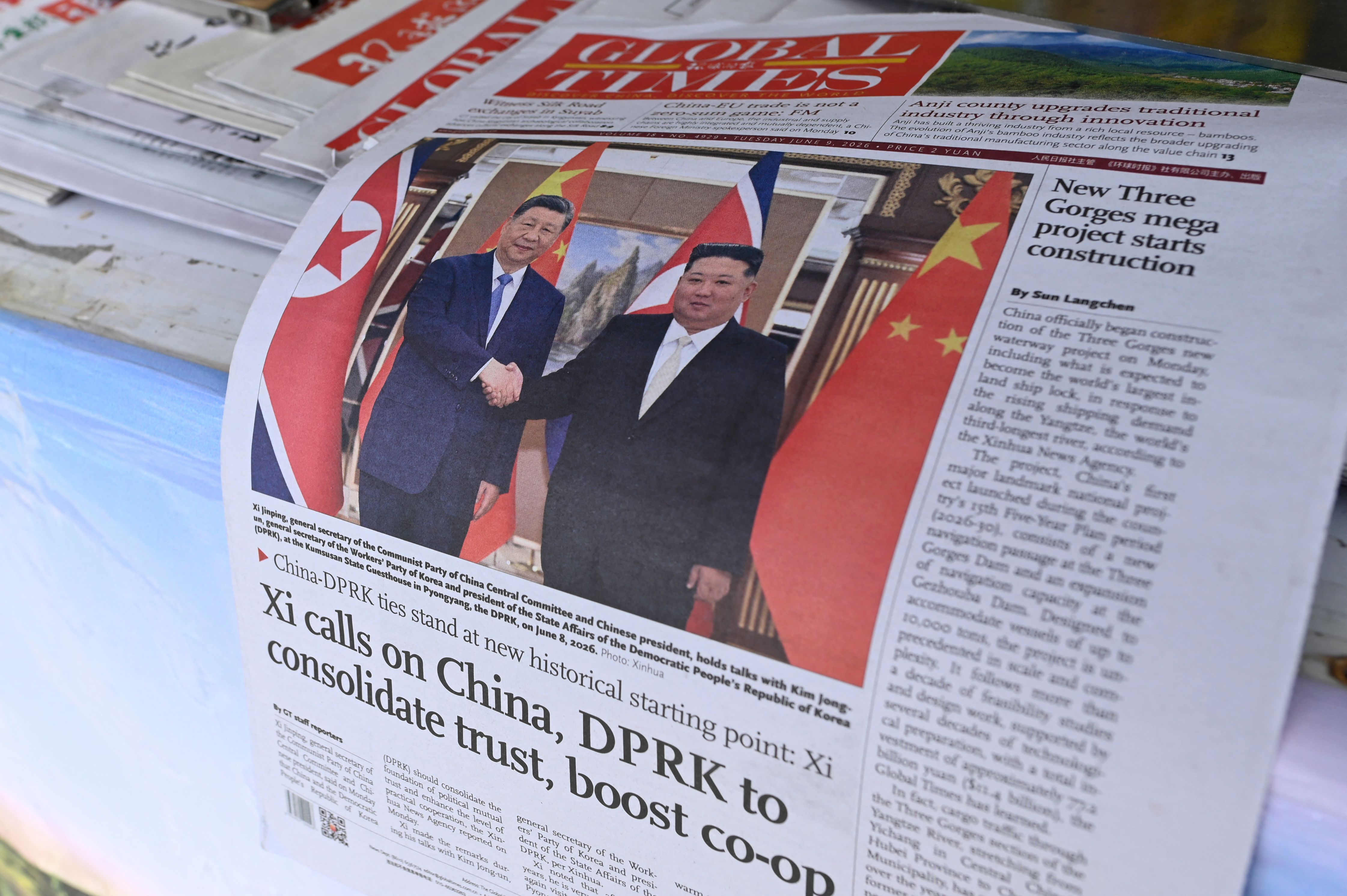 A newspaper front page photo shows Chinese President Xi Jinping (L) shaking hands with North Korean leader Kim Jong Un in Pyongyang, as seen at a news stand in Beijing on June 9, 2026.