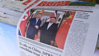 A newspaper front page photo shows Chinese President Xi Jinping (L) shaking hands with North Korean leader Kim Jong Un in Pyongyang, as seen at a news stand in Beijing on June 9, 2026.