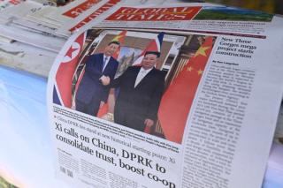 A newspaper front page photo shows Chinese President Xi Jinping (L) shaking hands with North Korean leader Kim Jong Un in Pyongyang, as seen at a news stand in Beijing on June 9, 2026.