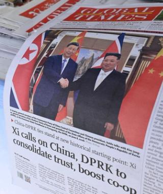 A newspaper front page photo shows Chinese President Xi Jinping (L) shaking hands with North Korean leader Kim Jong Un in Pyongyang, as seen at a news stand in Beijing on June 9, 2026.