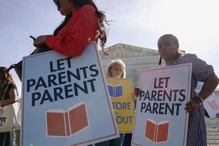 Protestors stand outside the US Supreme Court building holding 'let parents parent' signs