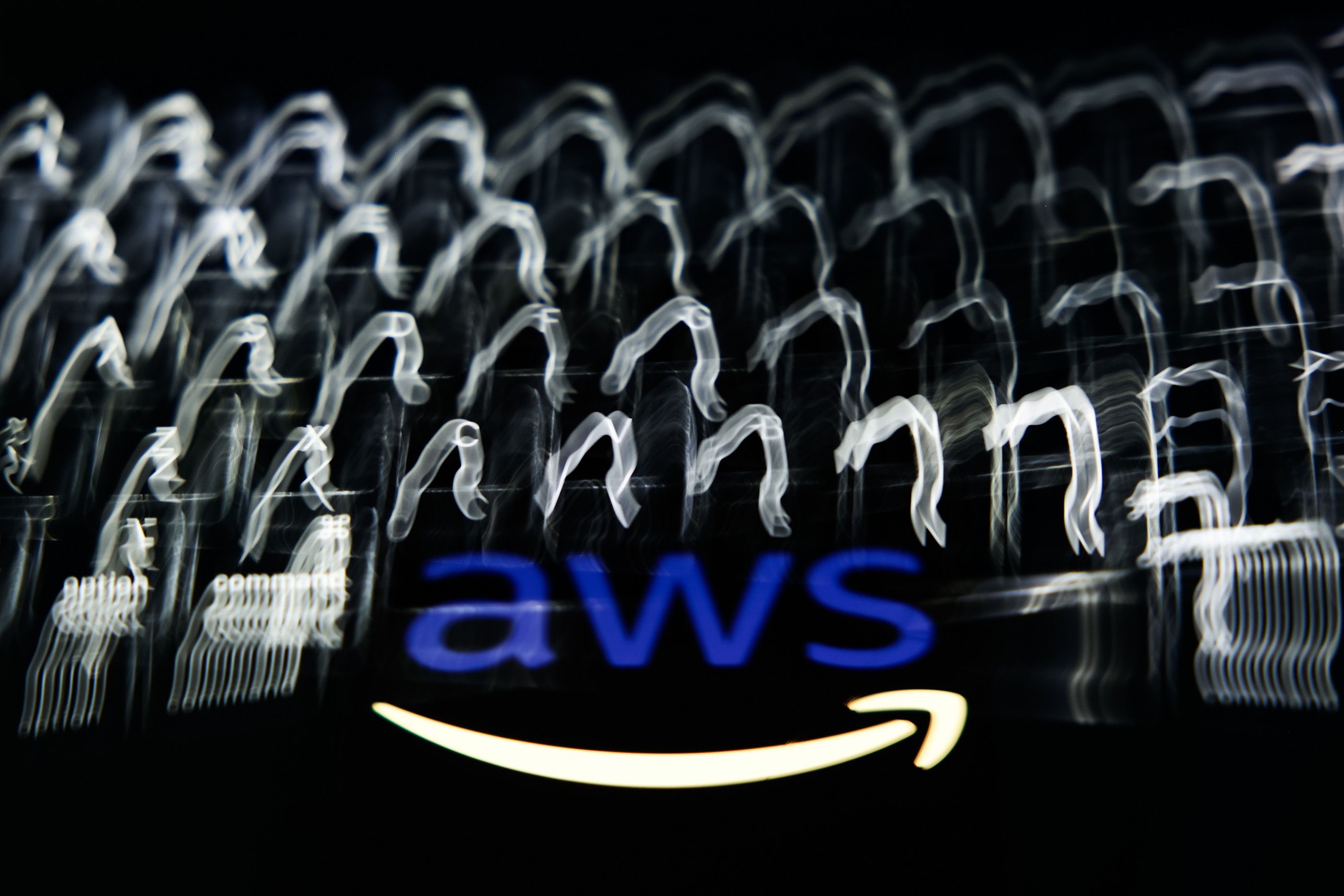 A laptop keyboard and AWS logo in a multiple exposure photo.