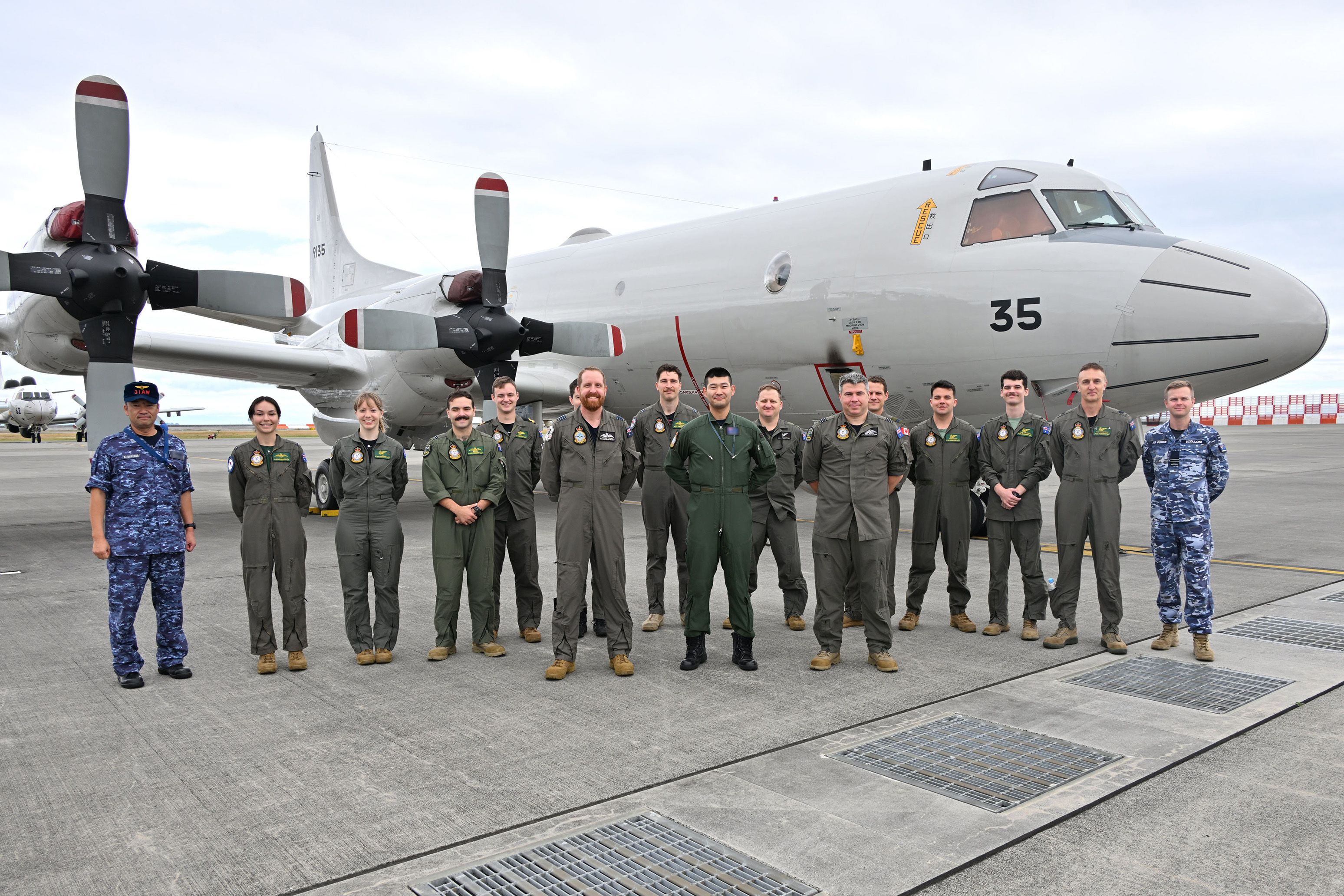Aviators from RAAF No 11 Squadron with Japan Maritime Self-Defense Force (JMSDF) 31st Fleet Air Wing and a P-3C Orion during an engagement visit at JMSDF Iwakuni Air Base in Japan. 