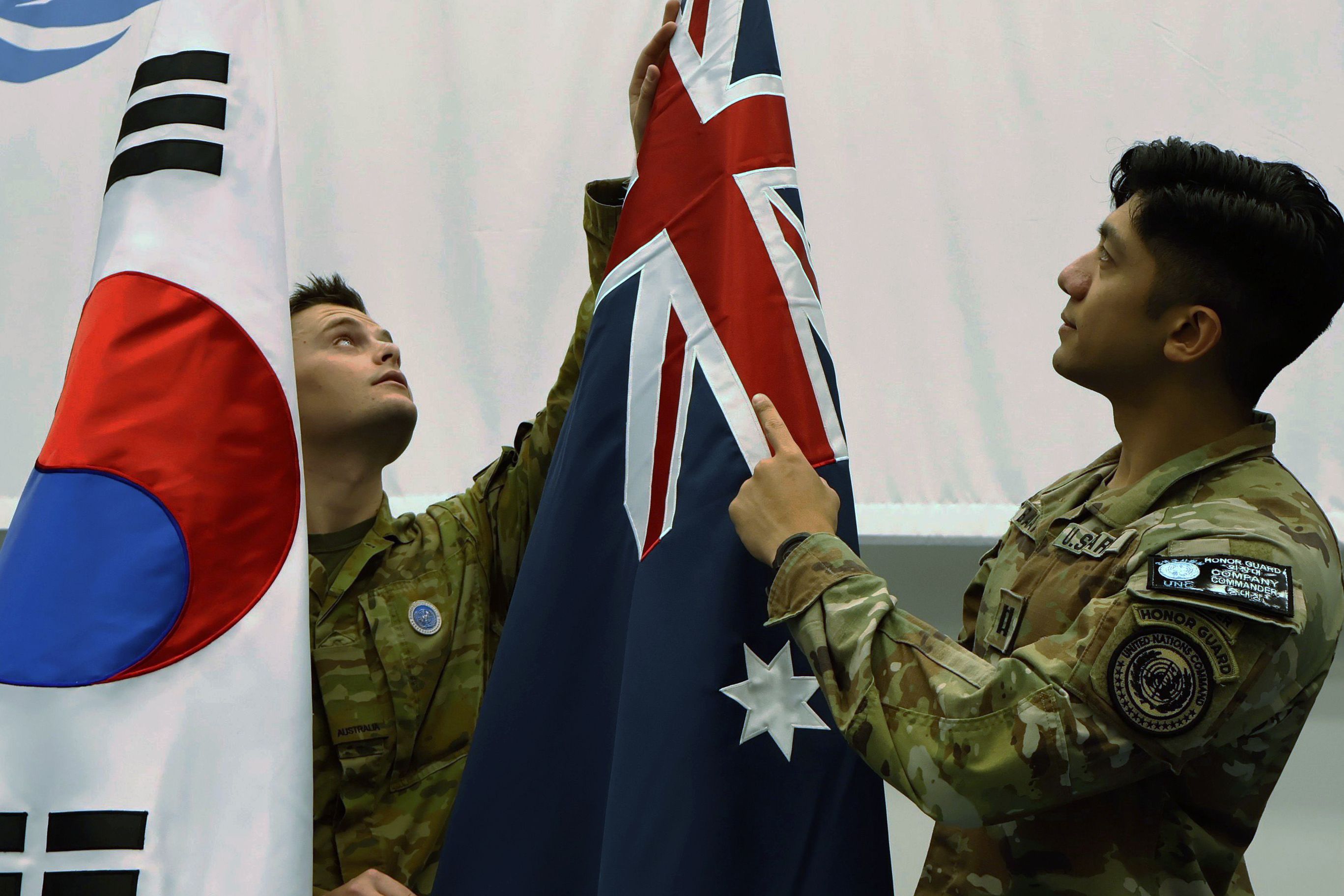 Private Kieran Findlay and UNC Honor Guard Company Commander Captain Zachary Balitaan prepare the Republic of Korea and Australian flags in the Honor Guard drill hall in Pyeongtaek, Republic of Korea