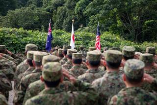 Australian, Japanese and United States personnel salute their national flags during the opening ceremony of Exercise Orient Shield 2025 at Sekiyama Training Area, Japan