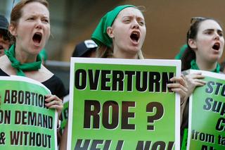 Three people protesting about abortion access in the US