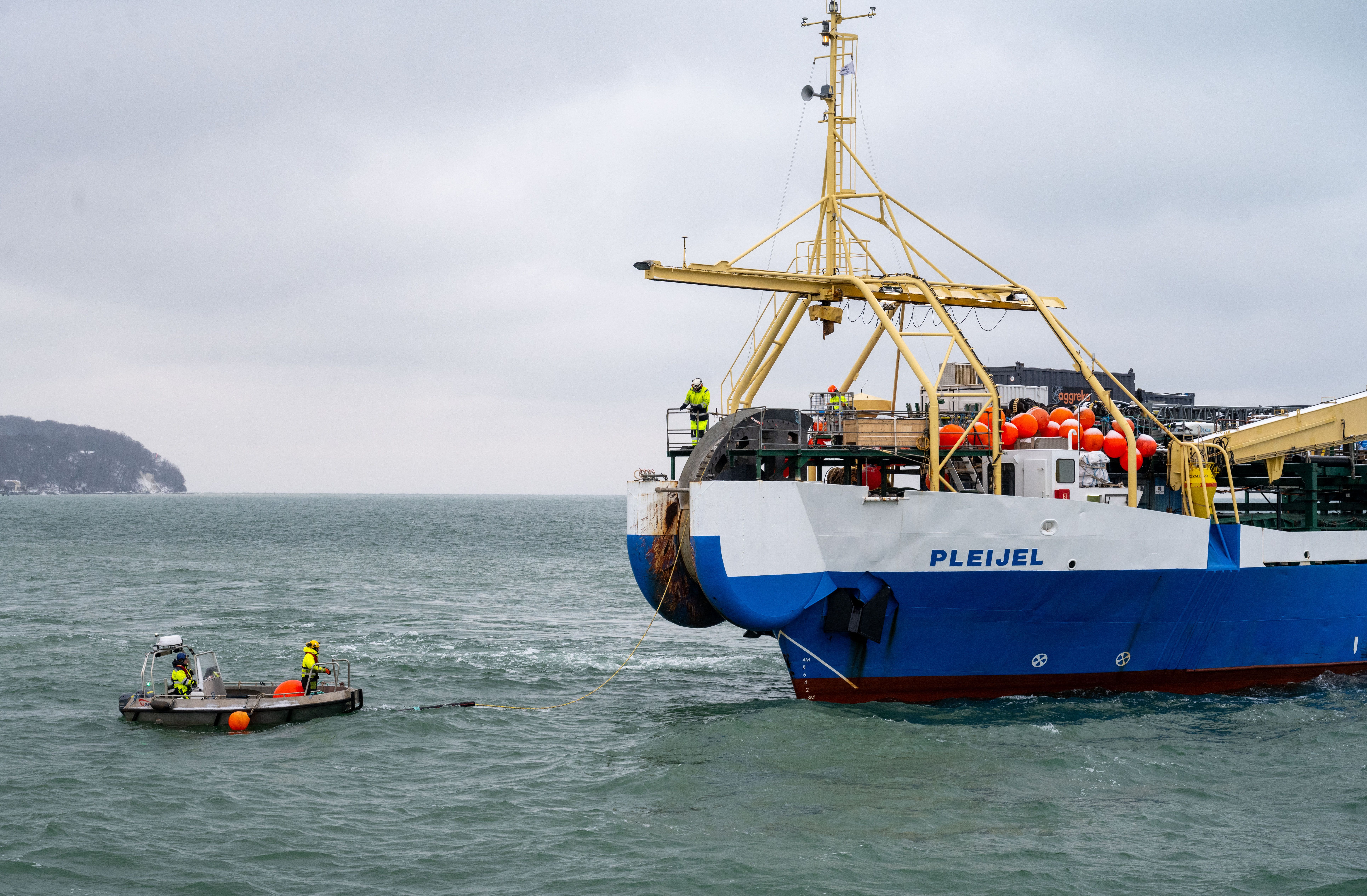 A fiber optic cable is pulled ashore from the cable-laying ship "Pleijel" at the entrance to the port of Sassnitz