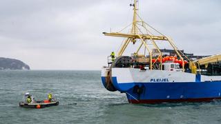 A fiber optic cable is pulled ashore from the cable-laying ship "Pleijel" at the entrance to the port of Sassnitz